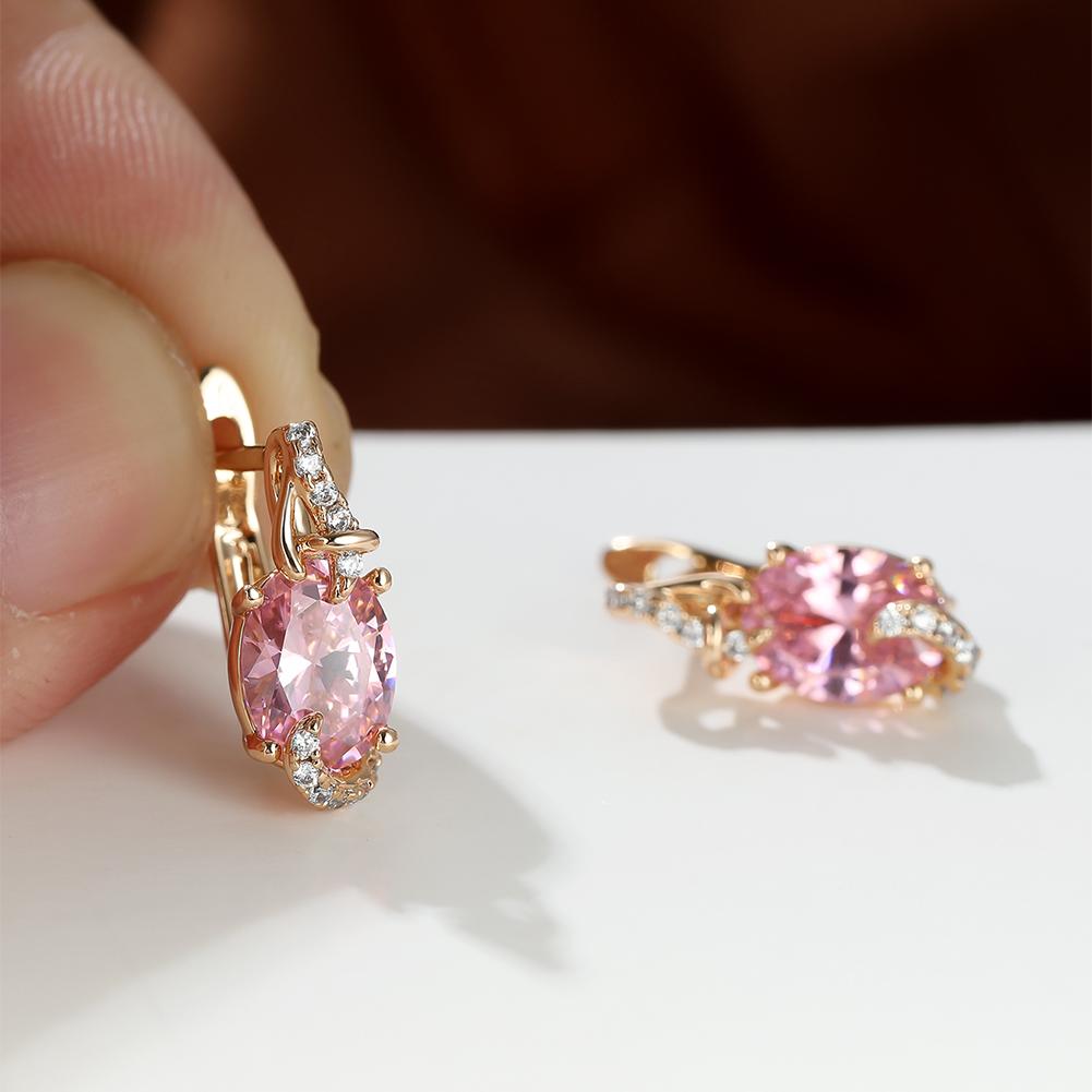 Plated pink stone drop earrings with oval cut, secured in claw setting, ideal for anniversaries and elegant outfits.