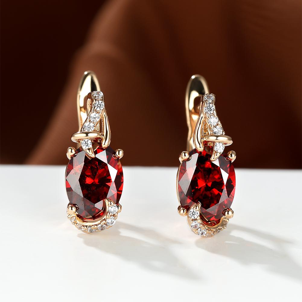 Trendy red oval-cut stone drop earrings with diamond accents in gold setting, perfect for anniversaries or elegant occasions.