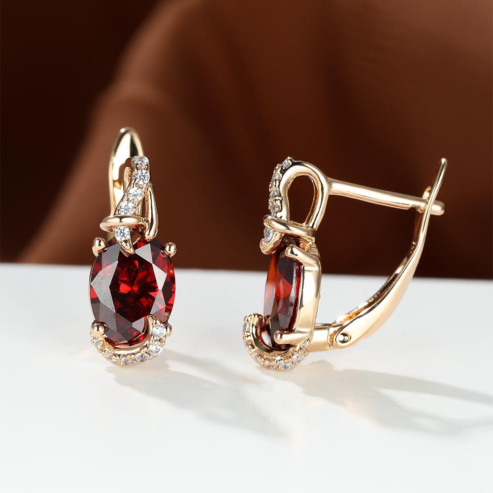 Trendy red oval cut stud earrings with a gold claw setting and sparkling accents, perfect for anniversaries or everyday wear.