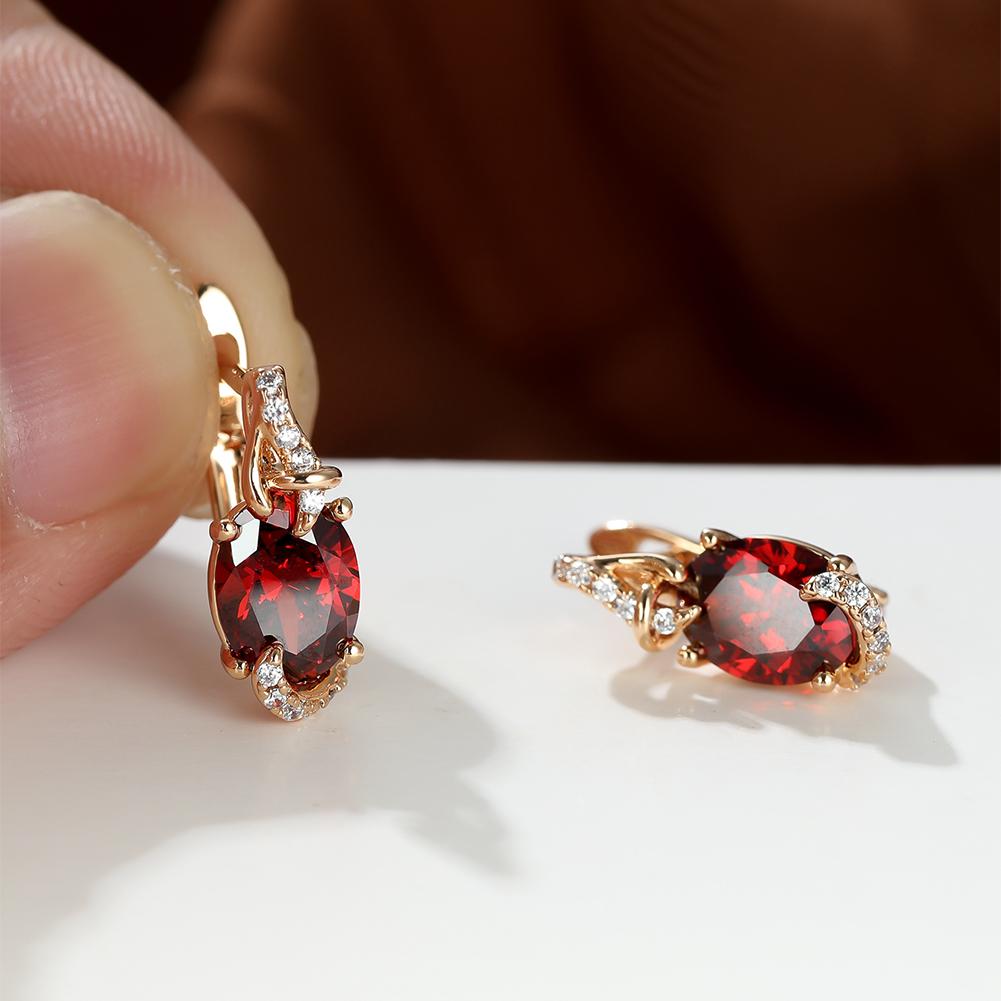 Elegant red oval-cut stone drop earrings with diamond accents and gold plating, perfect for special occasions and everyday wear.