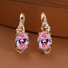Plated pink oval-cut stone drop earrings with sparkling accents, perfect for elegant occasions.