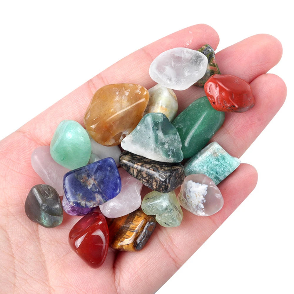Hand holding assorted irregular gemstone chakra healing stones in various colors for DIY jewelry and decor.
